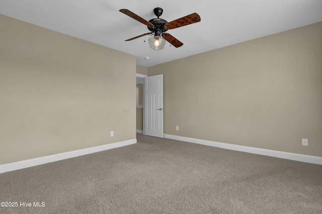 carpeted empty room featuring baseboards and ceiling fan