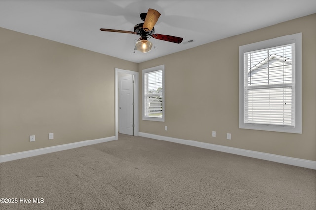 unfurnished room with baseboards, visible vents, ceiling fan, and carpet