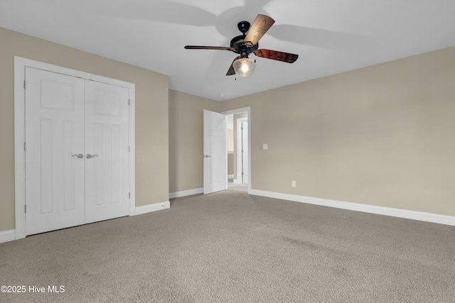 unfurnished bedroom featuring baseboards, ceiling fan, a closet, and carpet floors