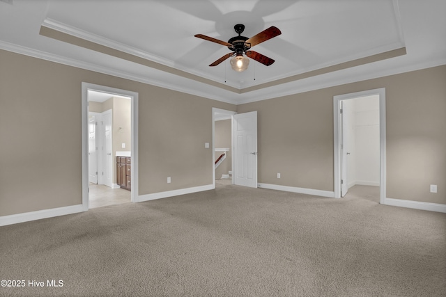 unfurnished bedroom featuring light colored carpet, ornamental molding, and a raised ceiling