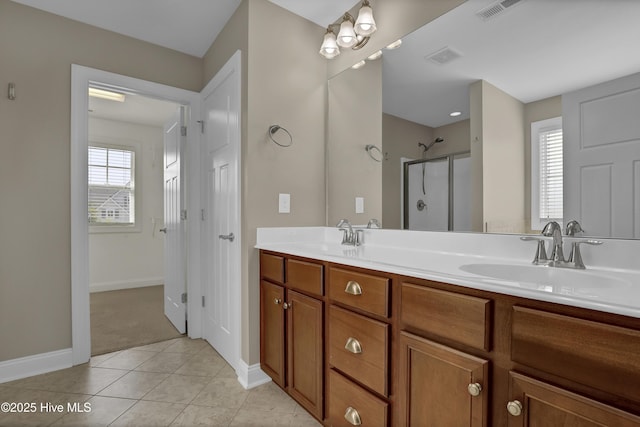bathroom featuring visible vents, a sink, baseboards, and a shower with door