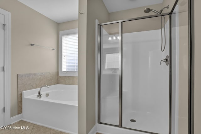 bathroom with baseboards, a shower stall, tile patterned floors, and a garden tub