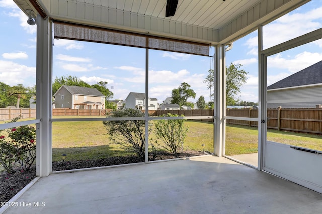 unfurnished sunroom with a residential view and a wealth of natural light