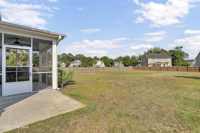 view of yard featuring fence, a sunroom, and a patio area