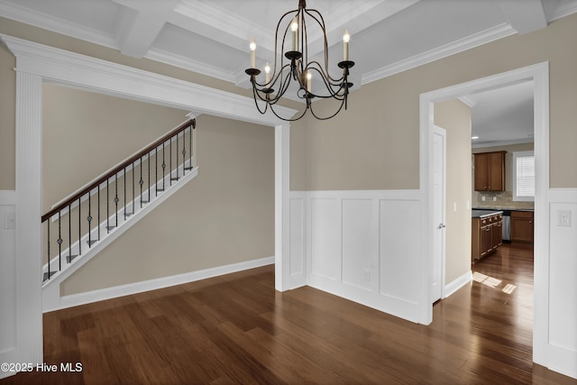 unfurnished dining area featuring crown molding, dark wood-style flooring, stairs, and a notable chandelier