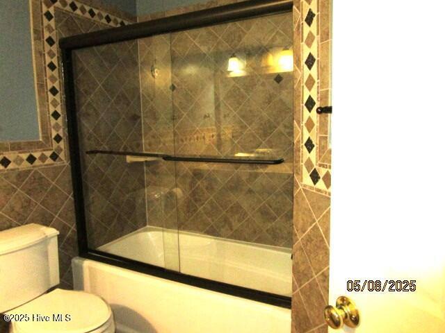 5001 Hewletts Run Unit 2, Wilmington, NC 28409 - bathroom featuring bath / shower combo with glass door and toilet