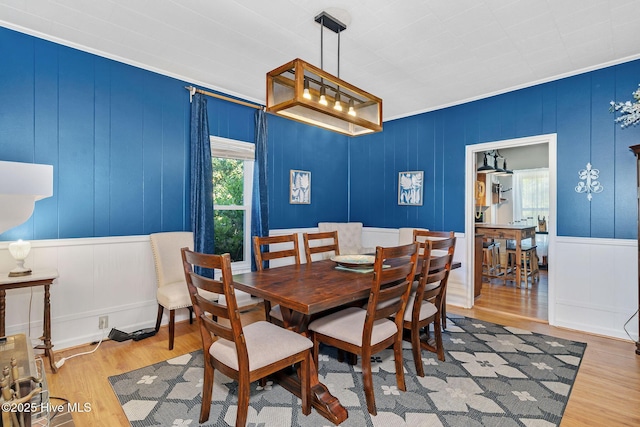 515 E Ridge St, Rose Hill, NC 28458 - dining space with a decorative wall, wood finished floors, and ornamental molding