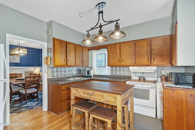 515 E Ridge St, Rose Hill, NC 28458 - kitchen with white appliances, brown cabinets, under cabinet range hood, a sink, and backsplash