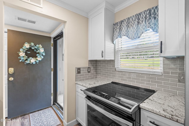 kitchen with visible vents, decorative backsplash, crown molding, electric range oven, and white cabinets