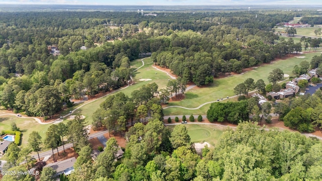 drone / aerial view featuring view of golf course and a forest view
