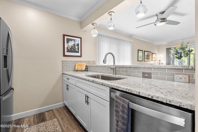 kitchen with backsplash, ceiling fan, appliances with stainless steel finishes, and a sink