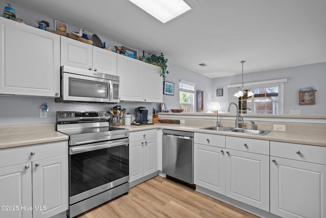 1164 Amber Pines Dr, Leland, NC 28451 - kitchen with light countertops, stainless steel appliances, white cabinets, and a sink
