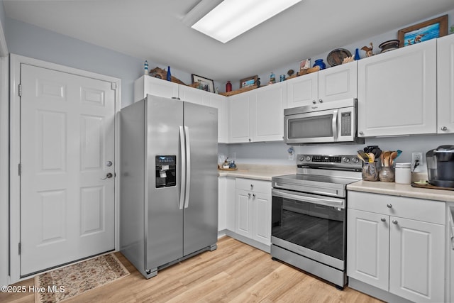 1164 Amber Pines Dr, Leland, NC 28451 - kitchen with stainless steel appliances, light countertops, light wood-type flooring, and white cabinets