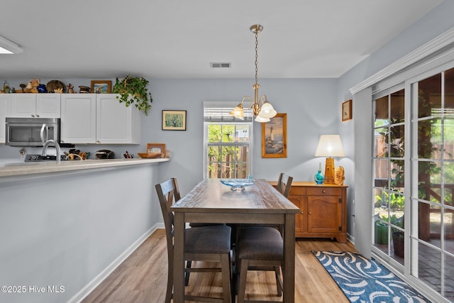 1164 Amber Pines Dr, Leland, NC 28451 - dining room featuring a chandelier, baseboards, light wood-type flooring, and visible vents