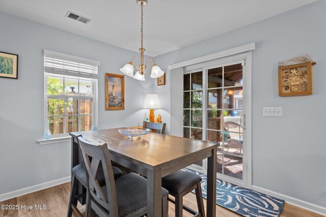 1164 Amber Pines Dr, Leland, NC 28451 - dining area featuring wood finished floors, visible vents, baseboards, and a notable chandelier