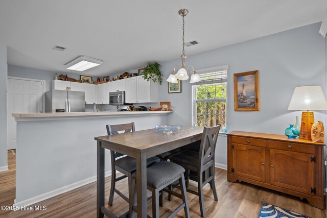 1164 Amber Pines Dr, Leland, NC 28451 - dining space with baseboards, light wood-style floors, a chandelier, and visible vents