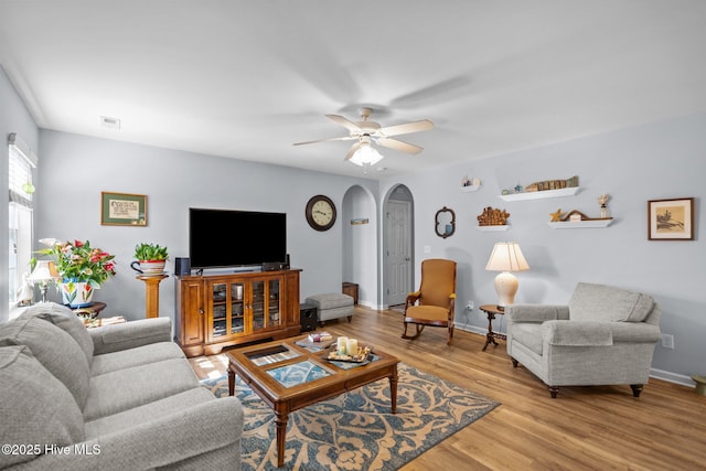 1164 Amber Pines Dr, Leland, NC 28451 - living area with visible vents, ceiling fan, light wood-style flooring, arched walkways, and baseboards