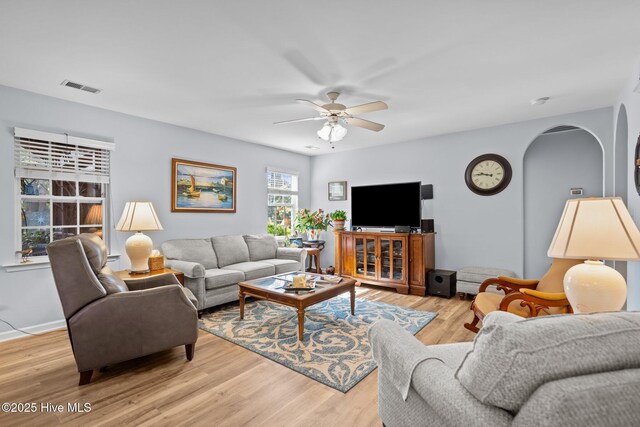 1164 Amber Pines Dr, Leland, NC 28451 - living room with a ceiling fan, baseboards, visible vents, arched walkways, and light wood-style floors