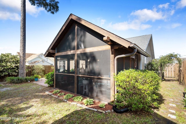 1164 Amber Pines Dr, Leland, NC 28451 - view of side of property featuring a sunroom, a shingled roof, and a fenced backyard