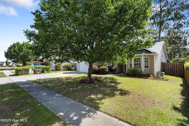 1164 Amber Pines Dr, Leland, NC 28451 - view of property hidden behind natural elements with driveway, fence, an attached garage, roof with shingles, and a front lawn