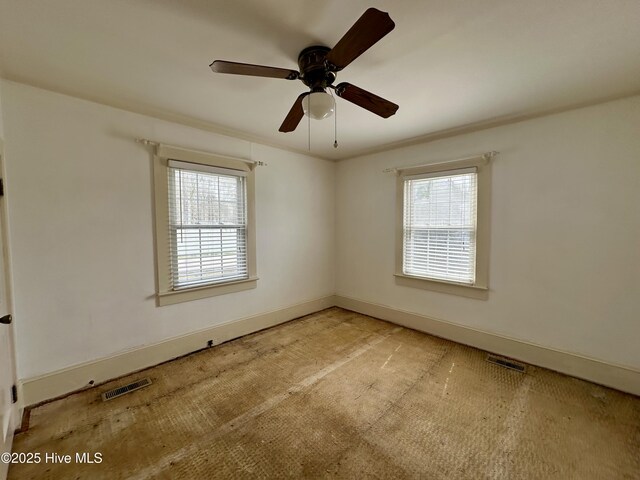 unfurnished room featuring carpet floors, baseboards, a ceiling fan, and visible vents