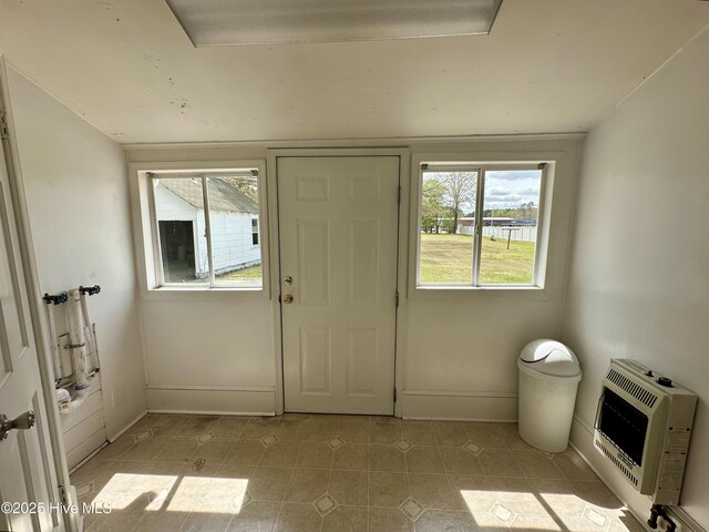 entryway featuring a water view, baseboards, and heating unit