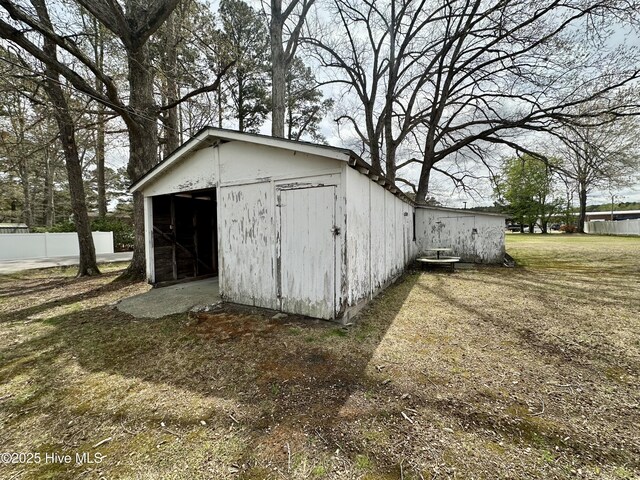 view of outbuilding with fence and an outbuilding
