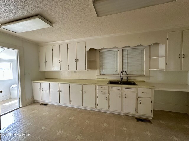 kitchen featuring visible vents, a sink, open shelves, and white cabinetry