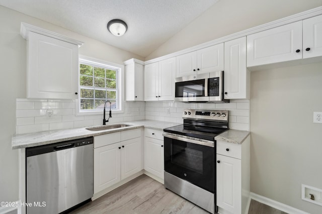 142 Burton Rd, Southport, NC 28461 - kitchen featuring a sink, stainless steel appliances, light wood-type flooring, and lofted ceiling