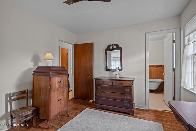 bedroom featuring ensuite bathroom, wood finished floors, and multiple windows