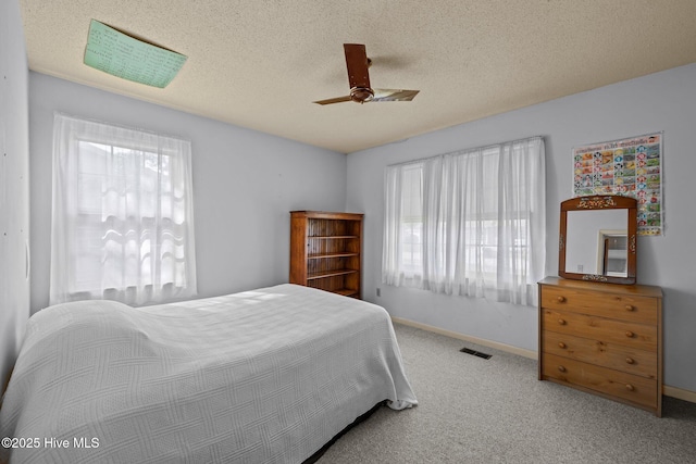 carpeted bedroom featuring baseboards, multiple windows, and ceiling fan