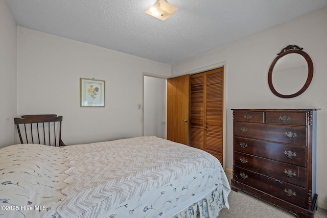 carpeted bedroom featuring a textured ceiling and a closet