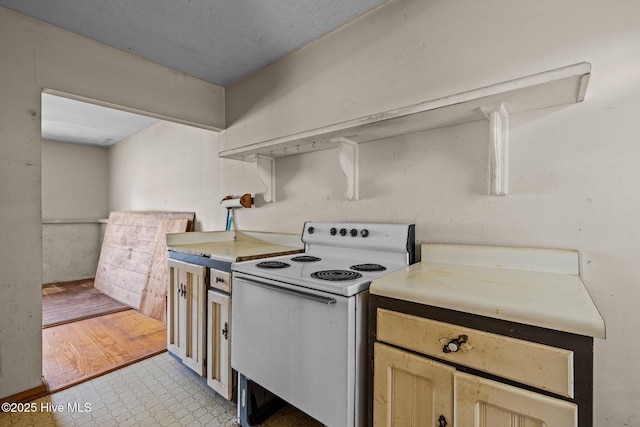 kitchen featuring light countertops and white range with electric cooktop