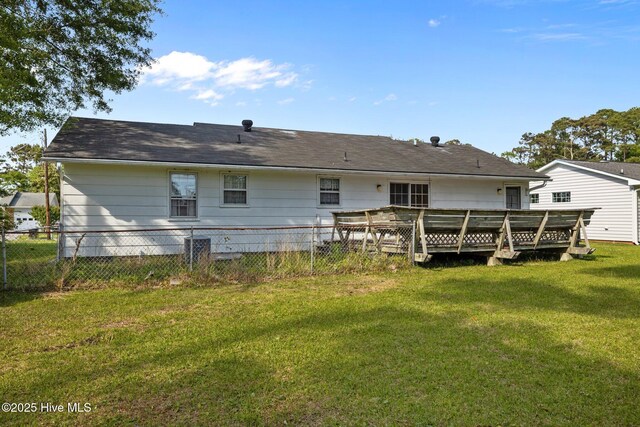back of house featuring a lawn, fence, and a wooden deck