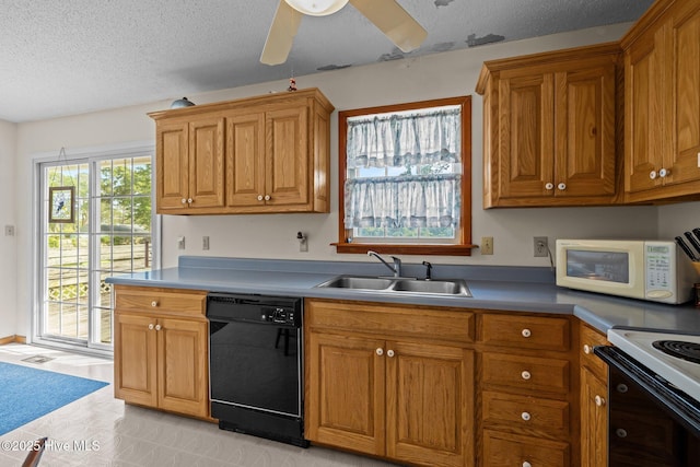 kitchen with brown cabinetry, a sink, dishwasher, and white microwave