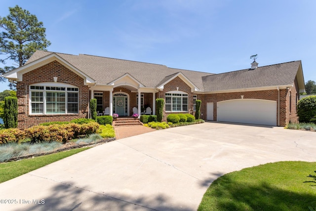 ranch-style home with brick siding, a garage, roof with shingles, and driveway