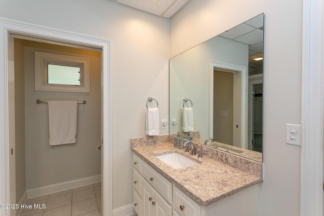 bathroom with vanity, baseboards, and tile patterned floors