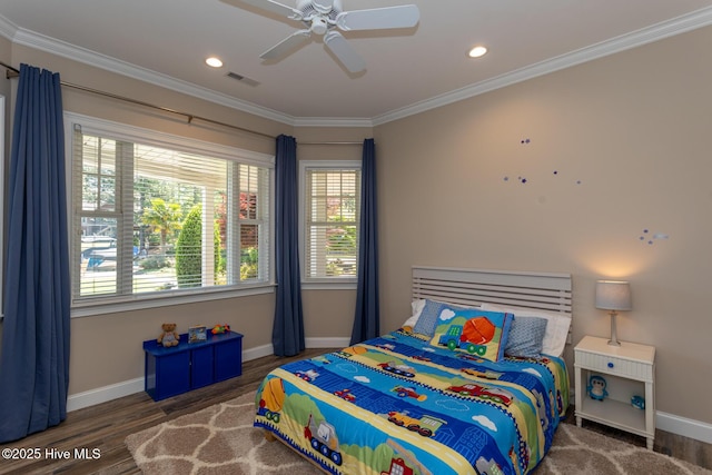 bedroom with crown molding, baseboards, wood finished floors, and visible vents