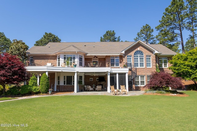 rear view of house featuring a ceiling fan, a yard, a patio area, and brick siding
