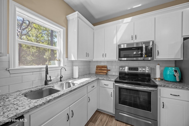 1203 English Colony Pl, Washington, NC 27889 - kitchen featuring stainless steel appliances, a sink, tasteful backsplash, and white cabinetry