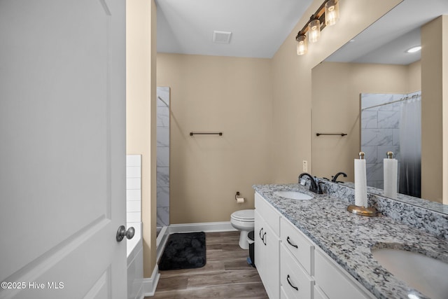 1203 English Colony Pl, Washington, NC 27889 - full bath featuring toilet, curtained shower, wood finished floors, baseboards, and double vanity