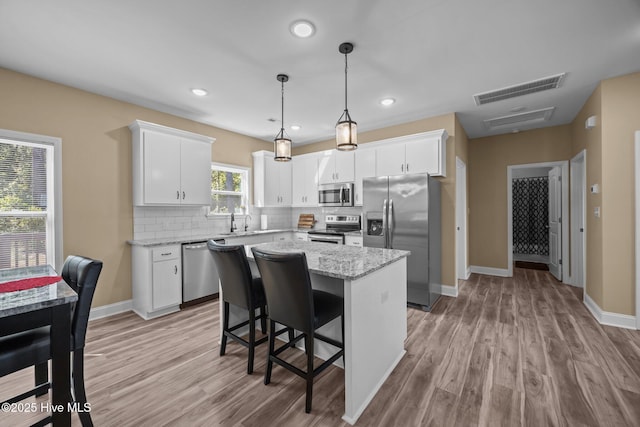 1203 English Colony Pl, Washington, NC 27889 - kitchen featuring appliances with stainless steel finishes, a sink, a kitchen island, light wood-style flooring, and recessed lighting