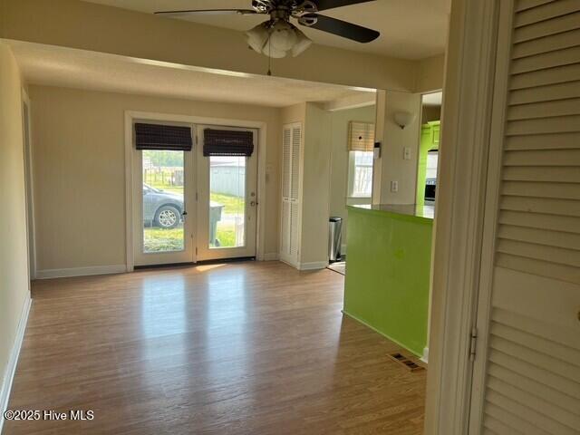 unfurnished room with baseboards, plenty of natural light, a ceiling fan, and visible vents