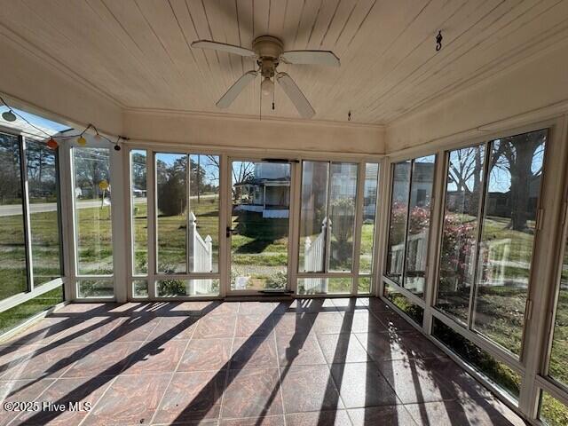 unfurnished sunroom with ceiling fan