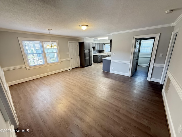 120 Ridgecrest Dr, Mount Olive, NC 28365 - unfurnished living room with dark wood-type flooring, ornamental molding, a textured ceiling, and a notable chandelier