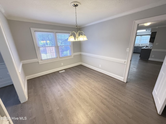 120 Ridgecrest Dr, Mount Olive, NC 28365 - unfurnished dining area with dark wood-type flooring, a textured ceiling, a notable chandelier, and a healthy amount of sunlight