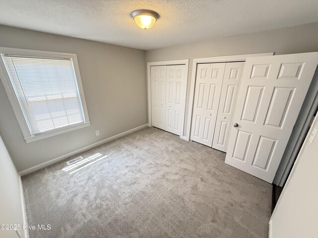 120 Ridgecrest Dr, Mount Olive, NC 28365 - unfurnished bedroom featuring visible vents, a textured ceiling, multiple closets, and carpet