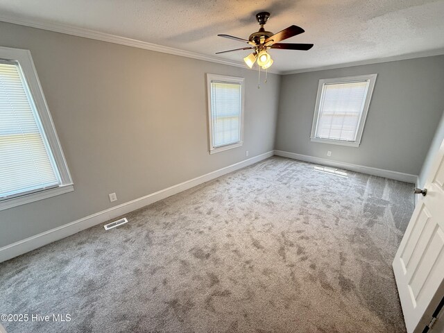 120 Ridgecrest Dr, Mount Olive, NC 28365 - carpeted empty room featuring a textured ceiling, visible vents, plenty of natural light, and ornamental molding
