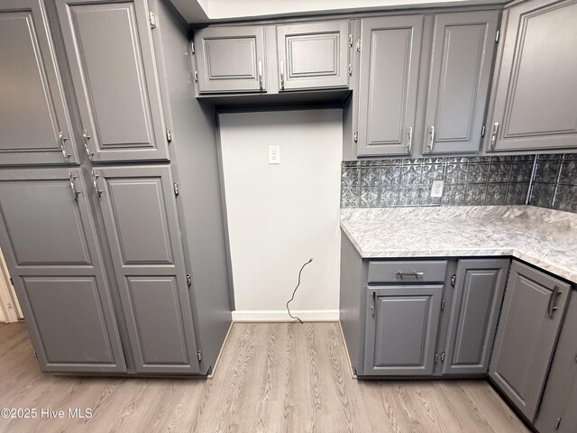 120 Ridgecrest Dr, Mount Olive, NC 28365 - kitchen with backsplash, gray cabinetry, light countertops, baseboards, and light wood-style flooring