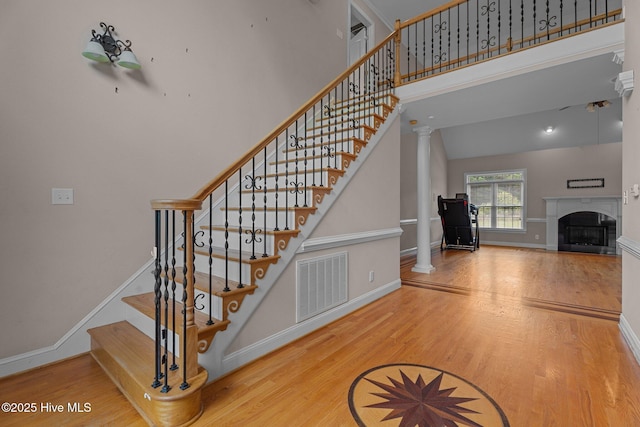 106 Cliffwell Dr, Goldsboro, NC 27530 - stairway with wood finished floors, baseboards, a fireplace, decorative columns, and a towering ceiling